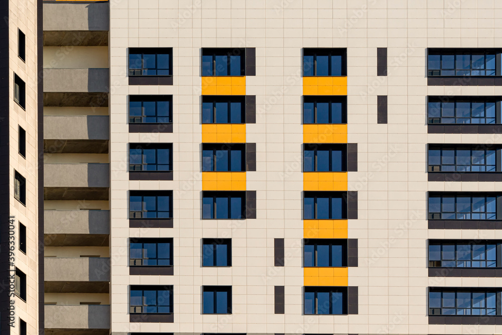 A row of windows on the ventilated facade of a typical modern residential building. Fragment of a new elite residential building or commercial complex