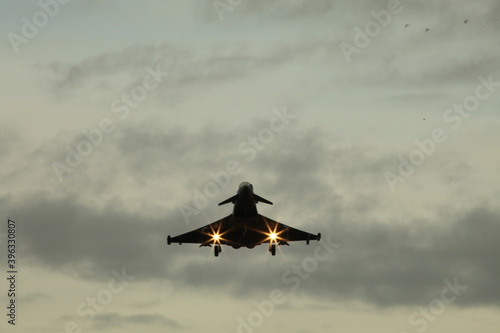 Military fighter jet landing with landing lights on  photo