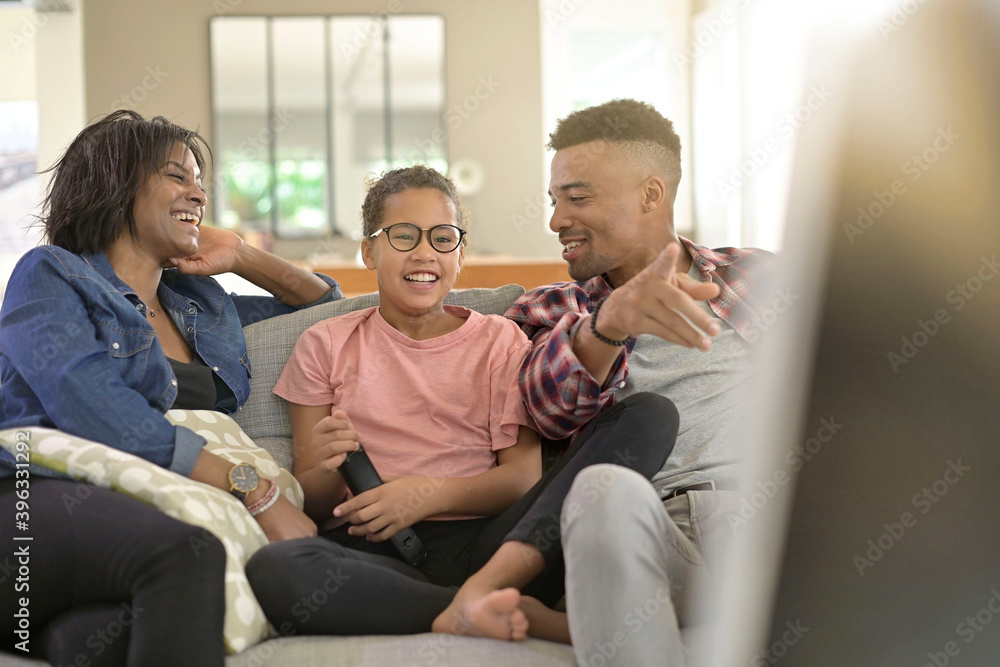 happy family sitting in sofa and watching tv together happy family sitting in sofa and watching tv together