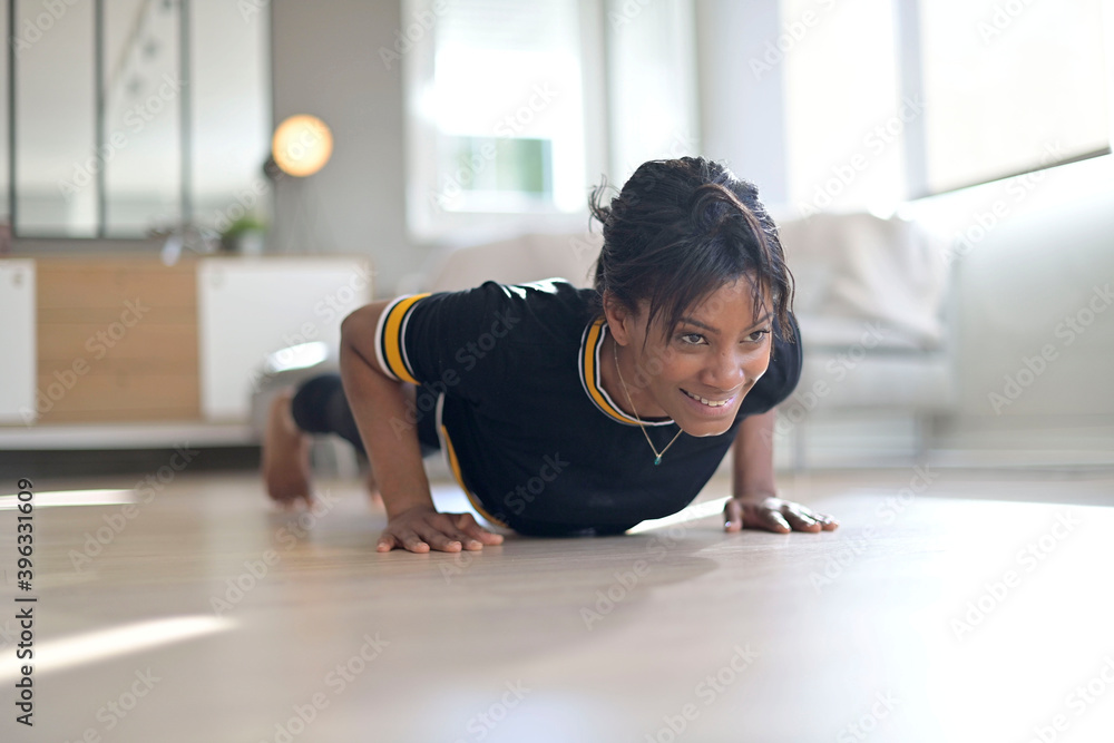 Athletic african-american woman doing fitness exercices at home