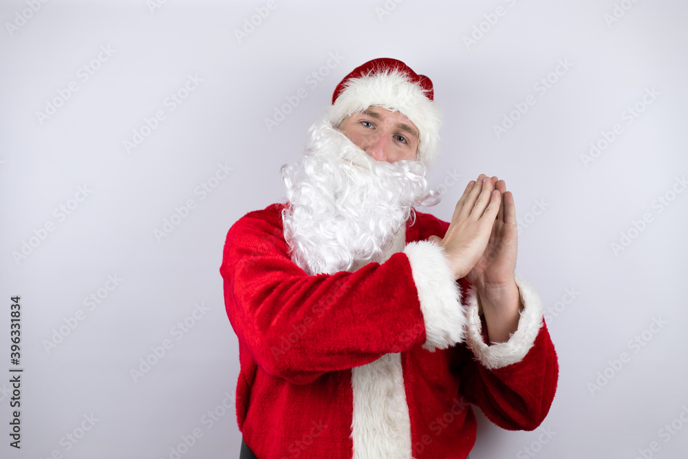 Man dressed as Santa Claus standing over isolated white background clapping and applauding happy and joyful, smiling proud hands together Man dressed as Santa Claus standing over isolated white background clapping and applauding happy and joyful, smiling proud hands together
