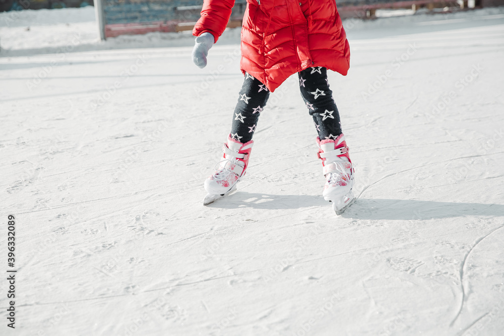 Figure skates on girl legs on ice covered with snow and with traces made by skating. Child winter outdoors on ice rink. Ice and legs Figure skates on girl legs on ice covered with snow and with traces made by skating. Child winter outdoors on ice rink. Ice and legs