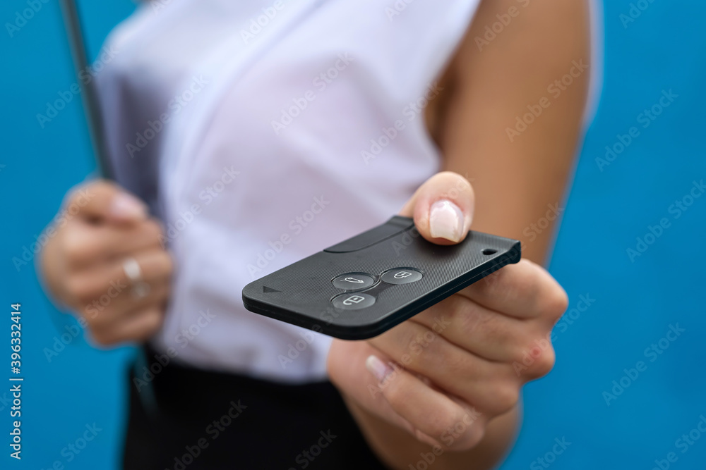 Young woman in business cloth hold car key on blue background Young woman in business cloth hold car key on blue background
