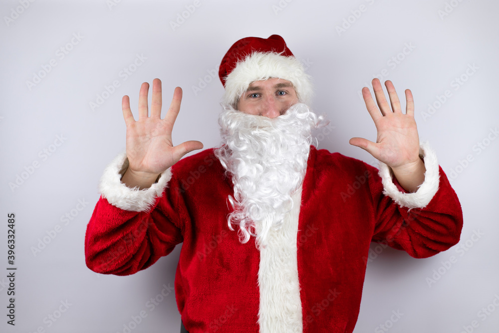 Man dressed as Santa Claus standing over isolated white background showing and pointing up with fingers number ten while smiling confident and happy Man dressed as Santa Claus standing over isolated white background showing and pointing up with fingers number ten while smiling confident and happy