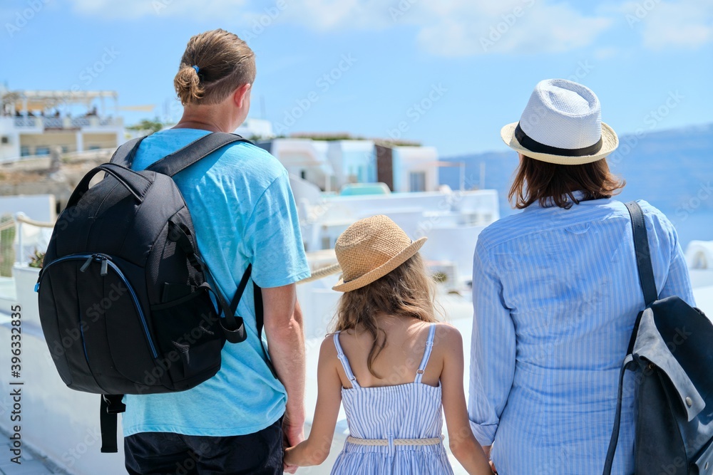 Mom dad and daughter happy travelers on the famous picturesque Greek island of Santorini