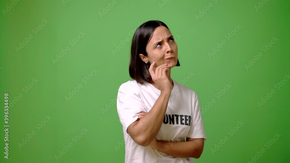 Young volunteer woman on green screen chroma key background having doubts and questioning an idea Young volunteer woman on green screen chroma key background having doubts and questioning an idea