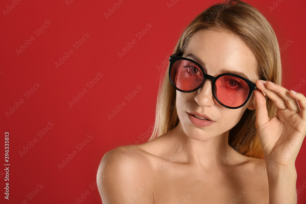 Beautiful woman in stylish sunglasses on red background. Space for text Beautiful woman in stylish sunglasses on red background. Space for text