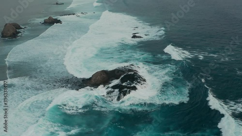 Aerial of rocky Gili Angkus at coast of Lombok with crashing waves photo