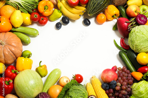 Frame of assorted fresh organic fruits and vegetables on white background, top view. Space for text