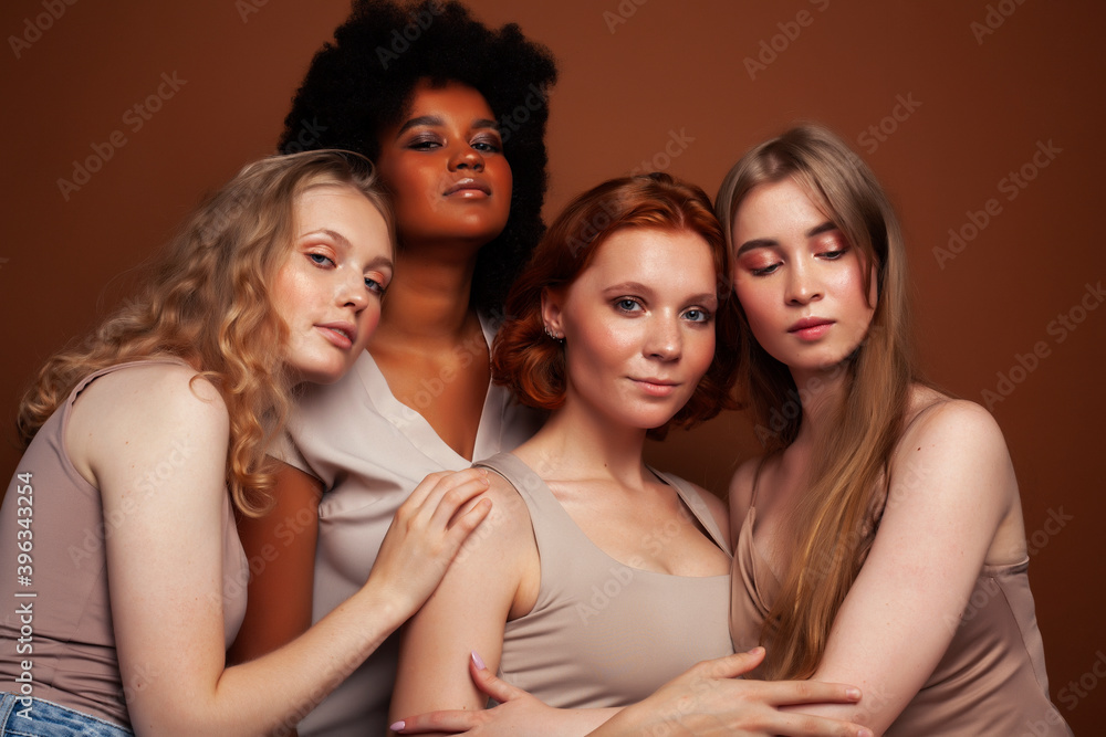 Obraz premium young pretty caucasian, afro, scandinavian woman posing cheerful together on brown background, lifestyle diverse nationality people concept