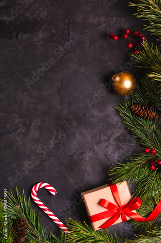 Christmas background decorated with pine branches, toys, candies and gift box