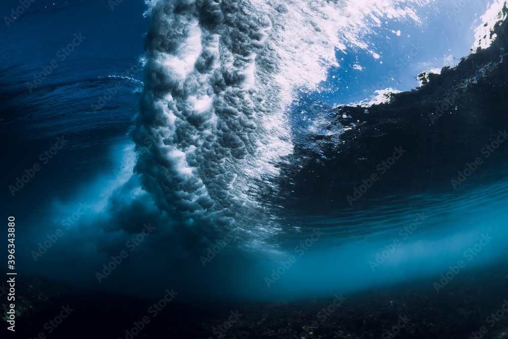 Breaking wave with foam and bubbles underwater. Transparent water