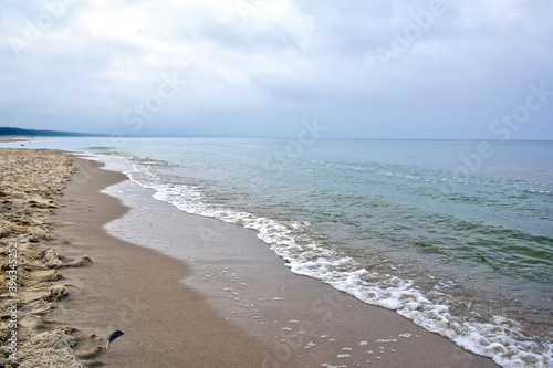 Sandy deserted seashore. Cold deserted beach