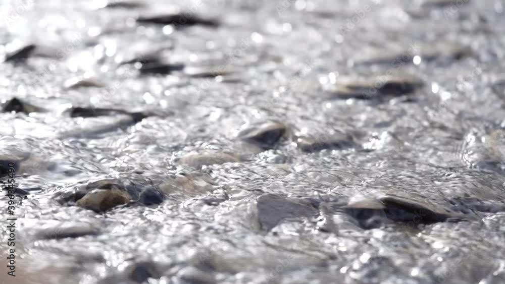 Slow motion water running over rocks and pebbles in a stream. Slow motion water running over rocks and pebbles in a stream.