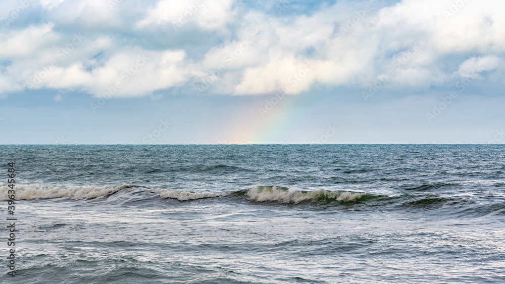 Rainbow over stormy sea after rain