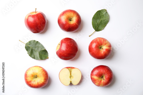Fresh ripe red apples and leaves on white background, flat lay