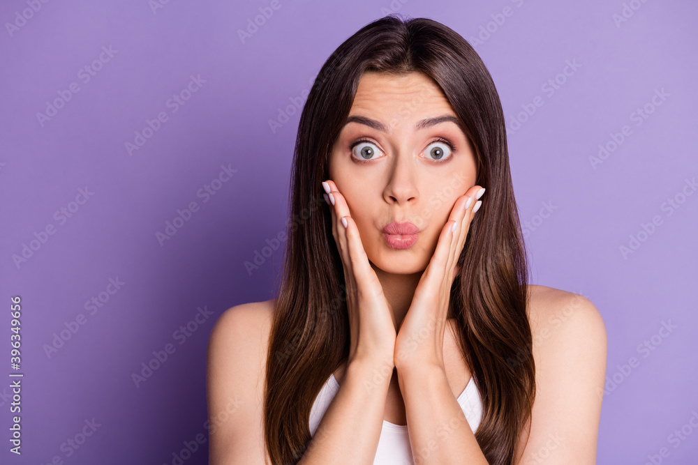 Photo portrait of cute pouting girl touching face cheeks with two hands isolated on vivid violet colored background Photo portrait of cute pouting girl touching face cheeks with two hands isolated on vivid violet colored background