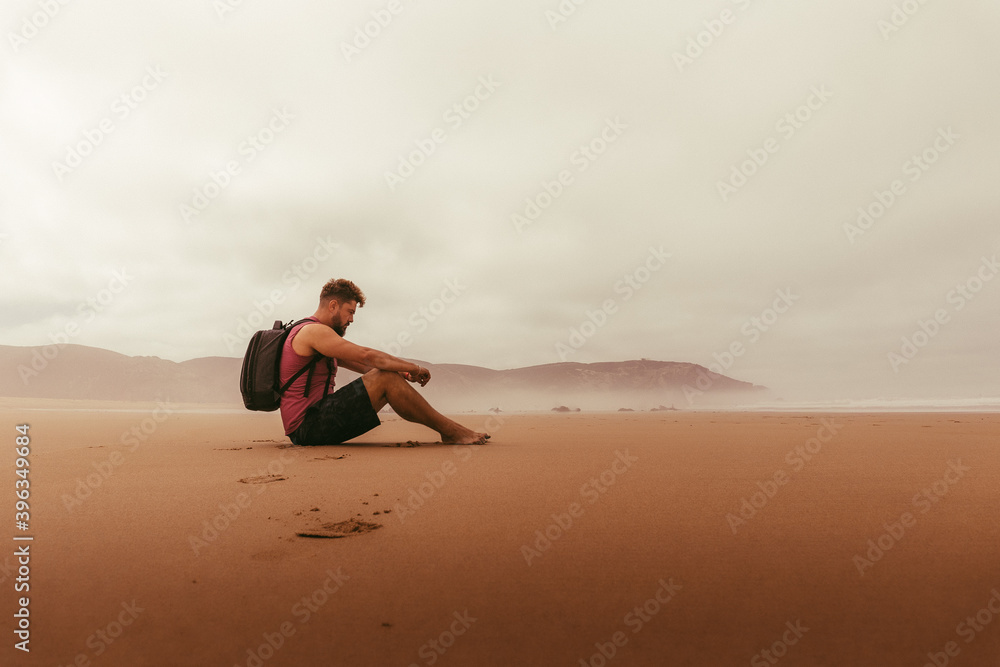 Lonely guy on red sand beach Lonely guy on red sand beach