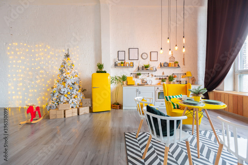 Trendy fashion luxury interior design in Scandinavian style of studio apartment with bright yellow furniture and decorated with new year lights. © 4595886