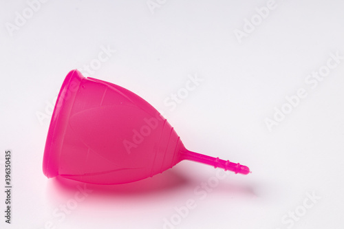 Pink silicone menstrual cup on white background