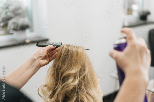 Girl in a hair salon, stylist make hair style for client in Woman's Hair In Hairdresser Salon, close view of hands