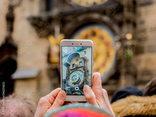 Photography An older lady taking a picture at the Prague astronomical clock