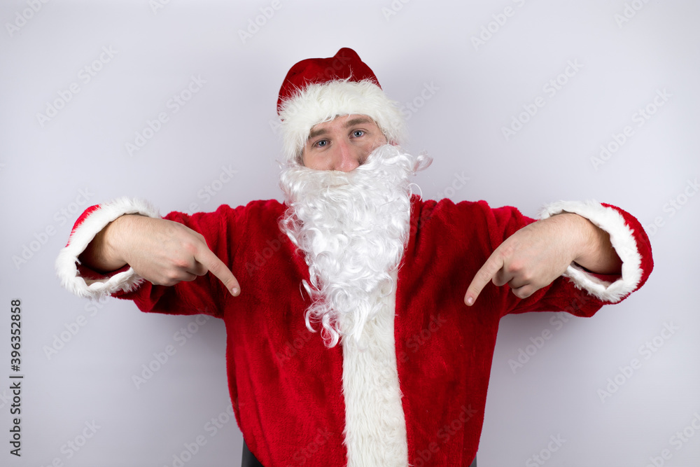 Man dressed as Santa Claus standing over isolated white background looking confident with smile on face, pointing oneself with fingers proud and happy. Man dressed as Santa Claus standing over isolated white background looking confident with smile on face, pointing oneself with fingers proud and happy.