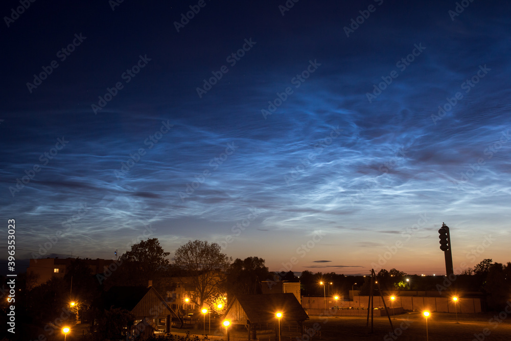 Silver clouds over small village. Noctilucent clouds, or night shining clouds, are tenuous cloud-like phenomena in the upper atmosphere of Earth. 