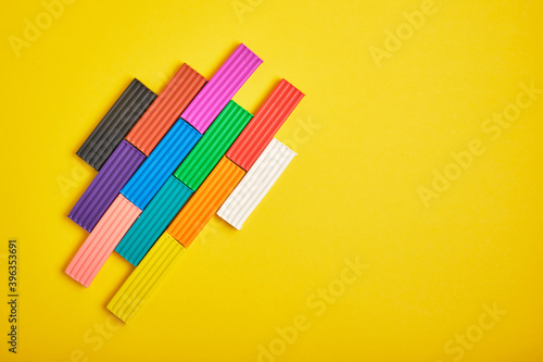 colored plasticine on yellow background copy space