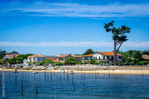 Yacht boat in the blue sea in front of the sand dune in Bassin d'arcachon to visit oysters farm 
