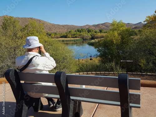A man bird watching at a scenic lake
