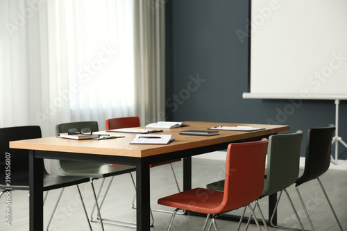 Modern meeting room interior with large table and projection screen © New Africa