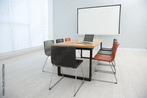 Conference room interior with wooden table and video projection screen © New Africa