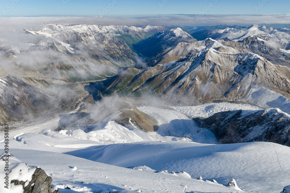 Above the mountains and clouds. View from the slope of Marble Wall Peak, Central Tian Shan, Kazakhstan - China.