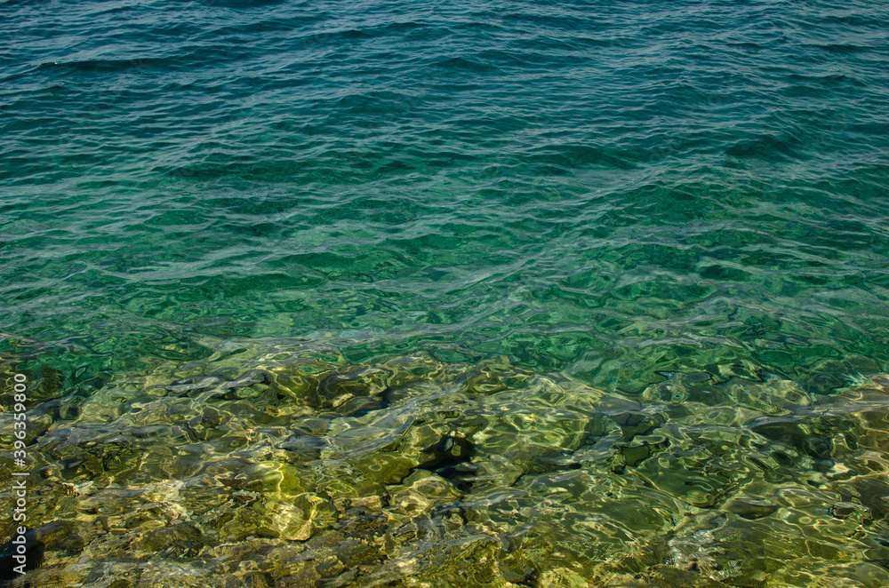 The rocky background of the sea throught emerald water, Croatia.