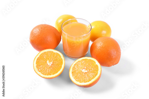 Orange juice in glass with oranges and lemon on white background