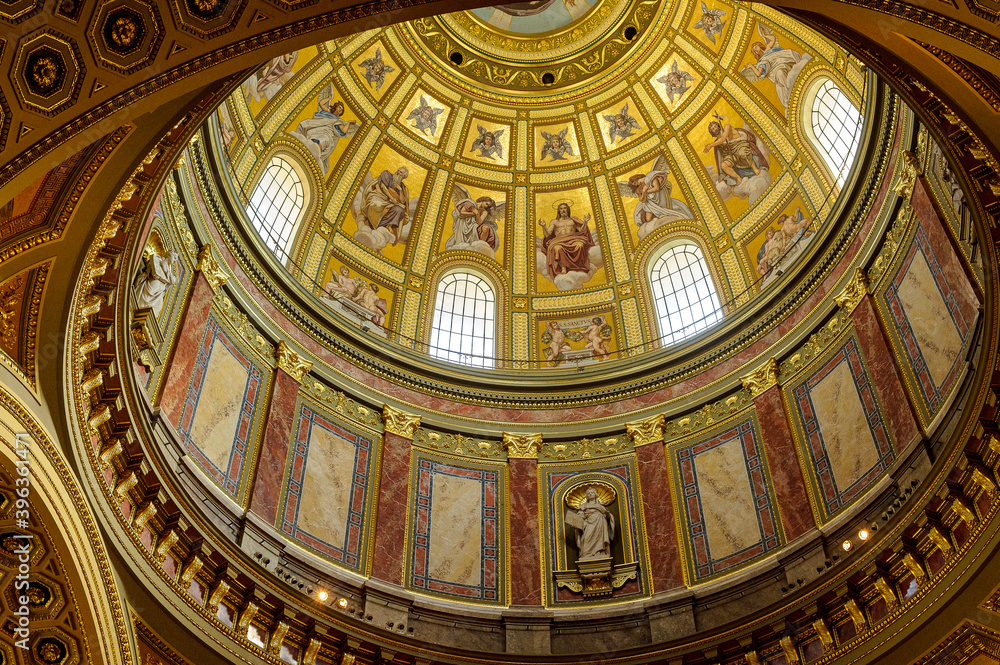 Saint Stephen's Basilica in Budapest, Hungary. Dome of the Saint Etienne Basilica. The vault is richly colored with golden hues and liturgical characters.