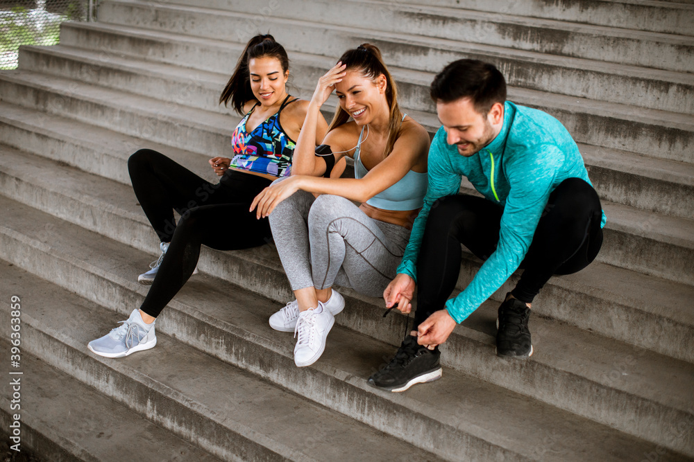 Fototapeta premium Young people resting during training with bottle of water