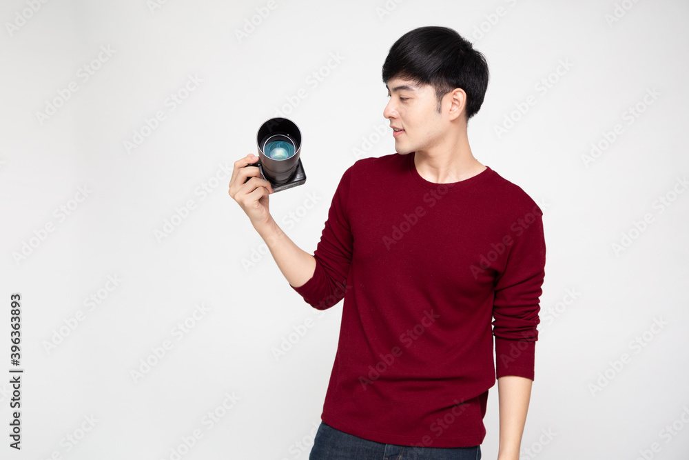 Fototapeta premium Young Asian man photographer holding camera isolated on white background