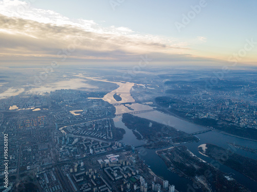 Aerial high flight over Kiev  haze over the city. Autumn morning  the Dnieper River is visible on the horizon.