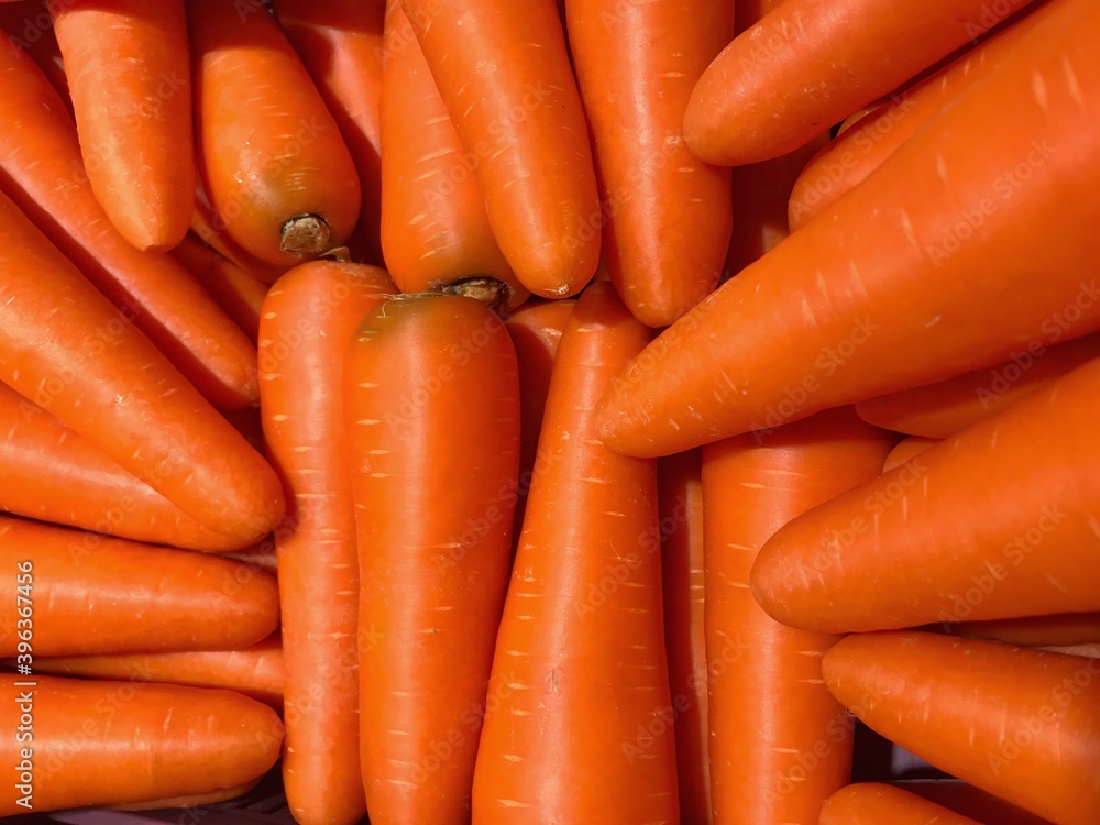 A photograph of an orange carrot full-frame and taken up close. A photograph of an orange carrot full-frame and taken up close.