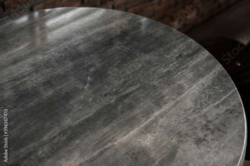 Round marble table with red brick in background