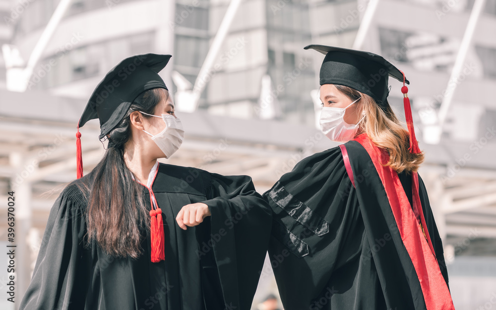 Obraz premium Two asian women wearing mask on graduation day