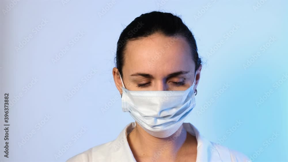 Closeup of Nurse Putting on Protective Mask and Medical Cap. Slow Motion. Healthcare and Medical Concept Closeup of Nurse Putting on Protective Mask and Medical Cap. Slow Motion. Healthcare and Medical Concept