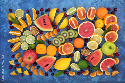 Healthy immune boosting large fruit collection high in antioxidants, anthocyanins, lycopene, dietary fibre, vitamin c & minerals Health care concept. Flat lay, top view on mottled blue. © marilyn barbone