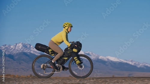 The woman travel on mixed terrain cycle touring with bikepacking. The traveler journey with bicycle bags. Sport tourism bikepacking. © ivandanru