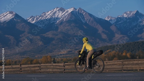 The woman travel on mixed terrain cycle touring with bikepacking. The traveler journey with bicycle bags. Sport tourism bikepacking. photo