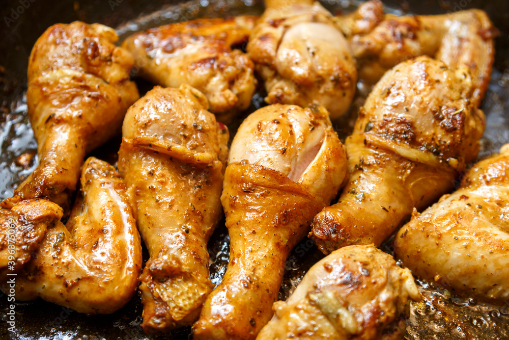 Chicken drumsticks and wings marinated with soy sauce on a baking sheet.