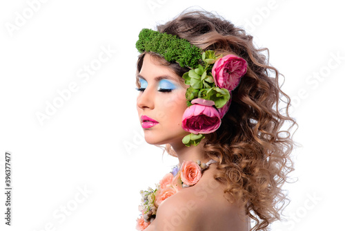 Young beautiful woman with colorful makeup and flowers in her curly hair. Isolate on a white background.