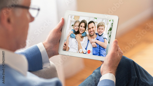 Senior Man Making Video Call With Family Online Sitting Indoor photo